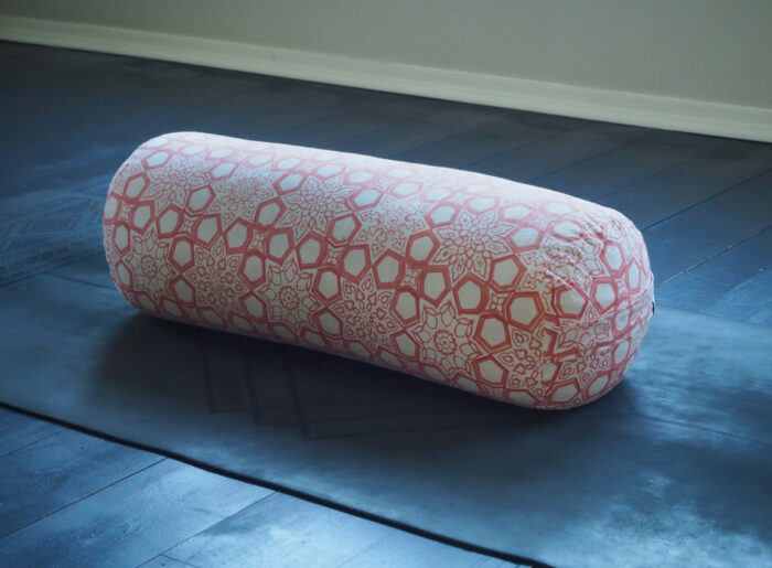 Yogipod Fretwork Jaipur Pink yoga bolster on a yoga mat