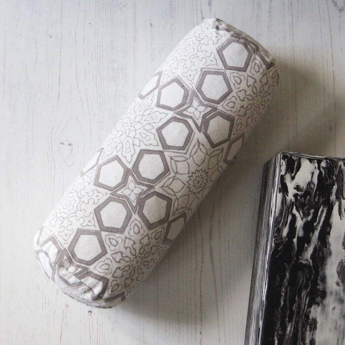 Yogipod mini bolster filled with buckwheat hulls with a handblock printed Fretwork design in grey