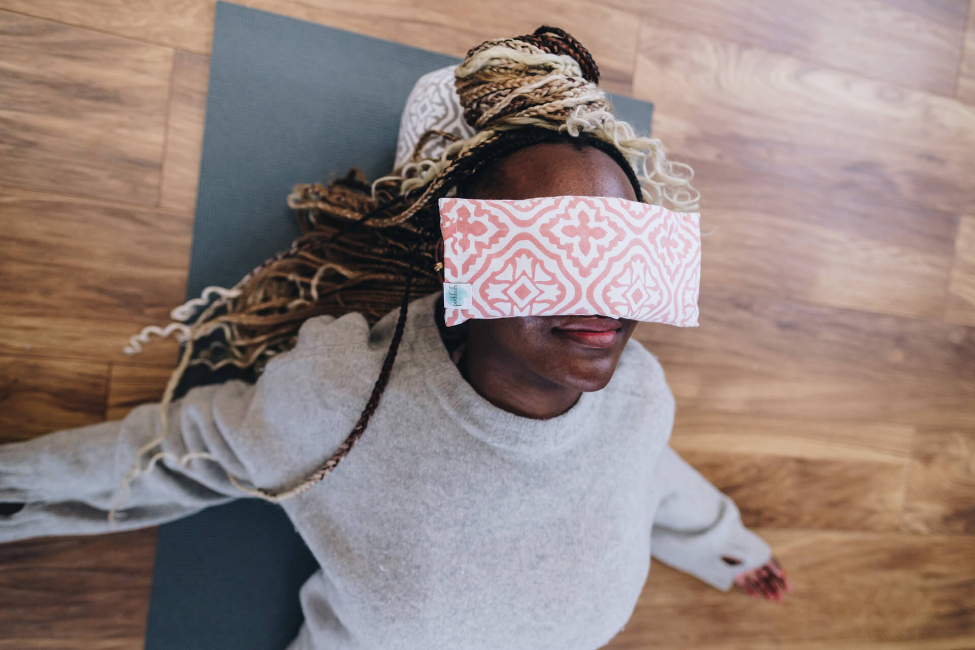 Ennette has a pink Yogipod eye pillow over her eyes which is soothing her nervous system